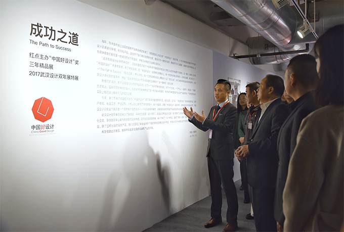 策展人陈昊洋先生（左一）给武汉市市长万勇（右三）介绍中国好设计奖
